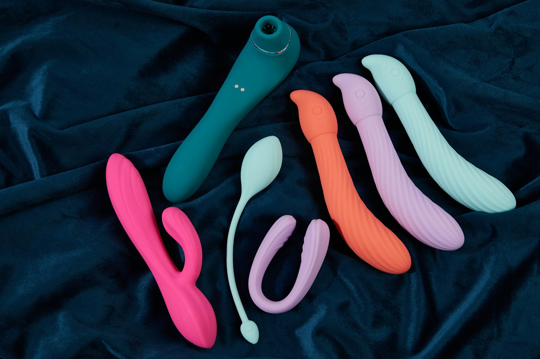 A blue silicone vibrator in hand against a purple background, symbolizing self-pleasure and sexual wellness.