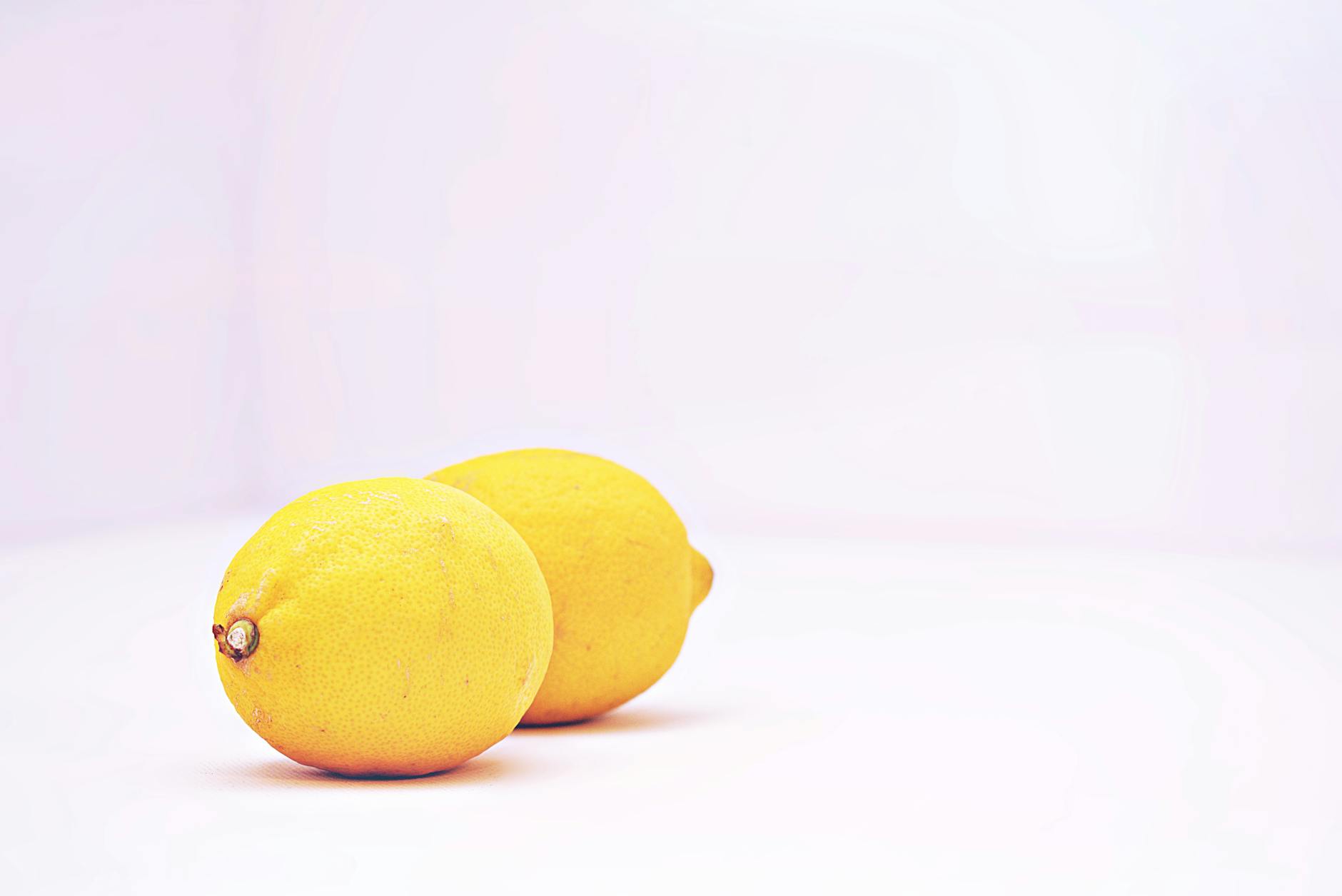 Fresh bright lemons on a clean white background, symbolizing clarity about medication effects on pleasure