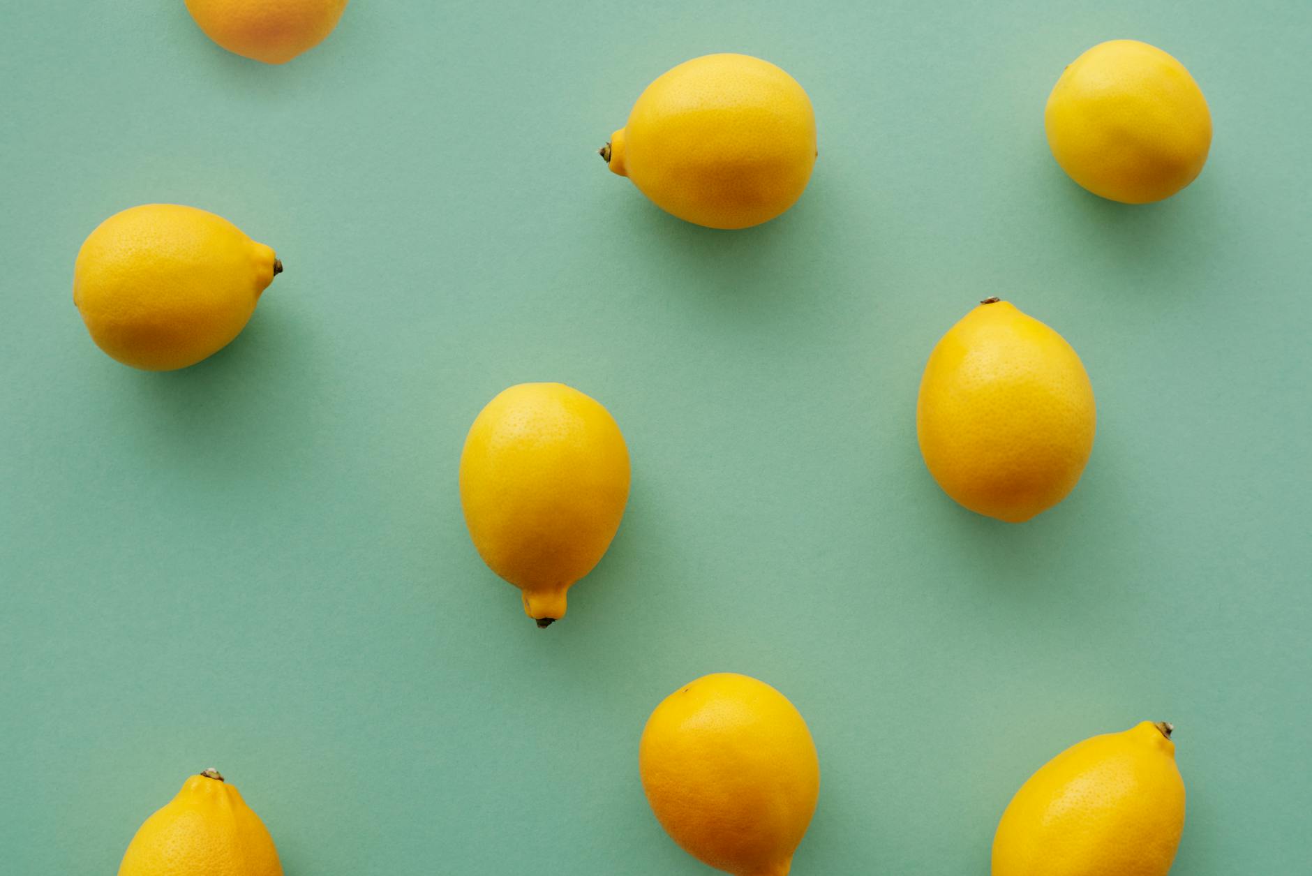 Bright yellow lemons arranged on a pastel green background, representing fresh approaches to intimacy.