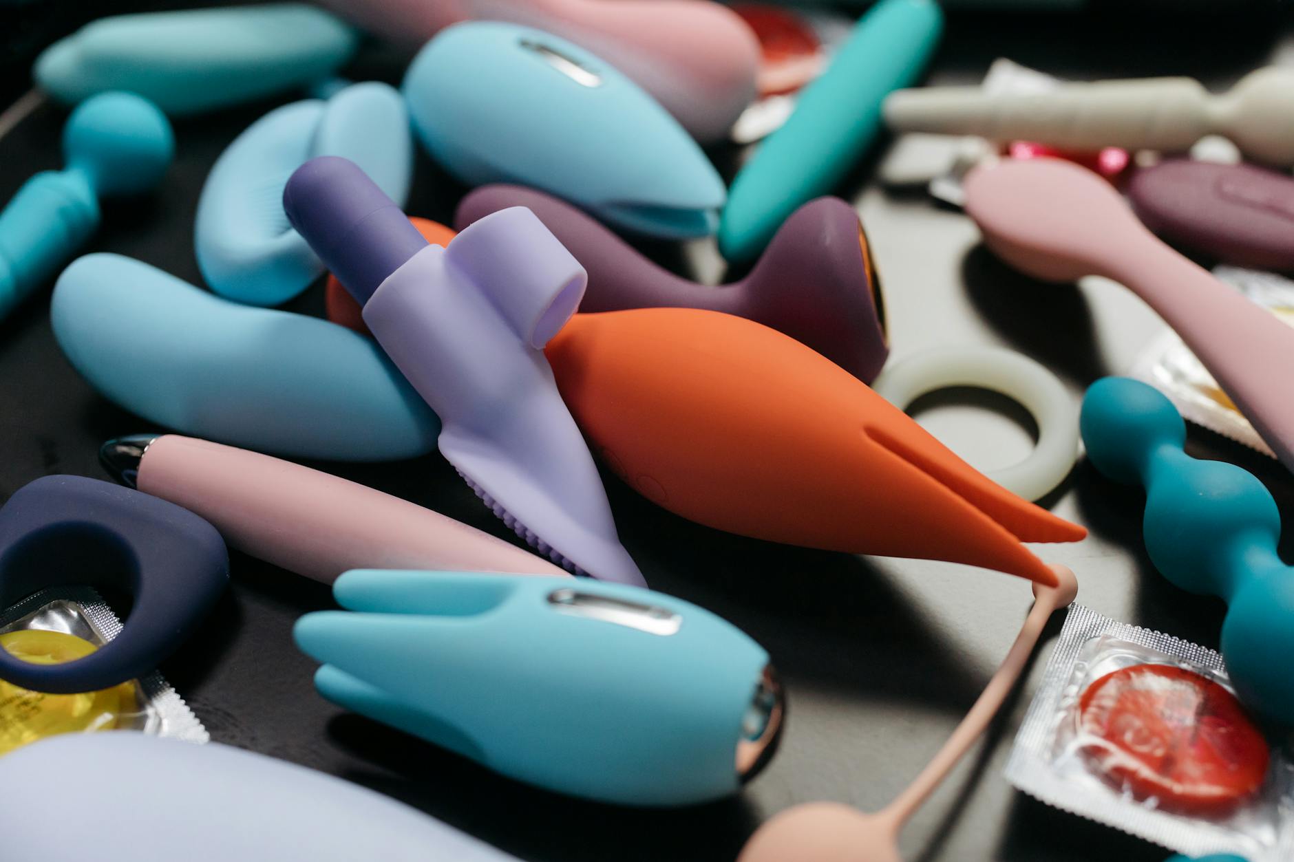 Woman holding blue and pink silicone vibrators, considering comfort and pleasure options
