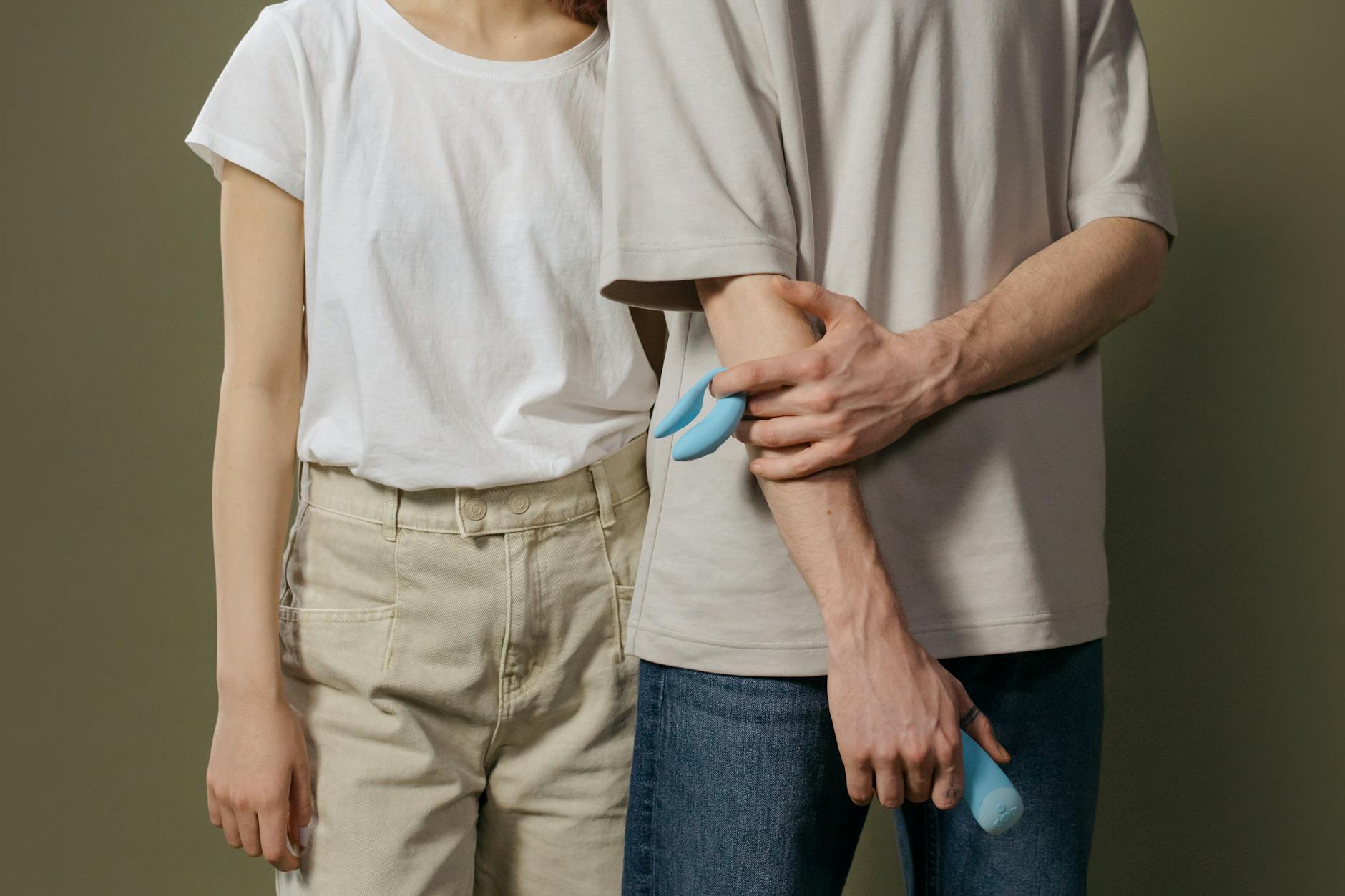 A hand holding a lemon-colored vibrator against a minimalist purple backdrop, representing modern pleasure practices